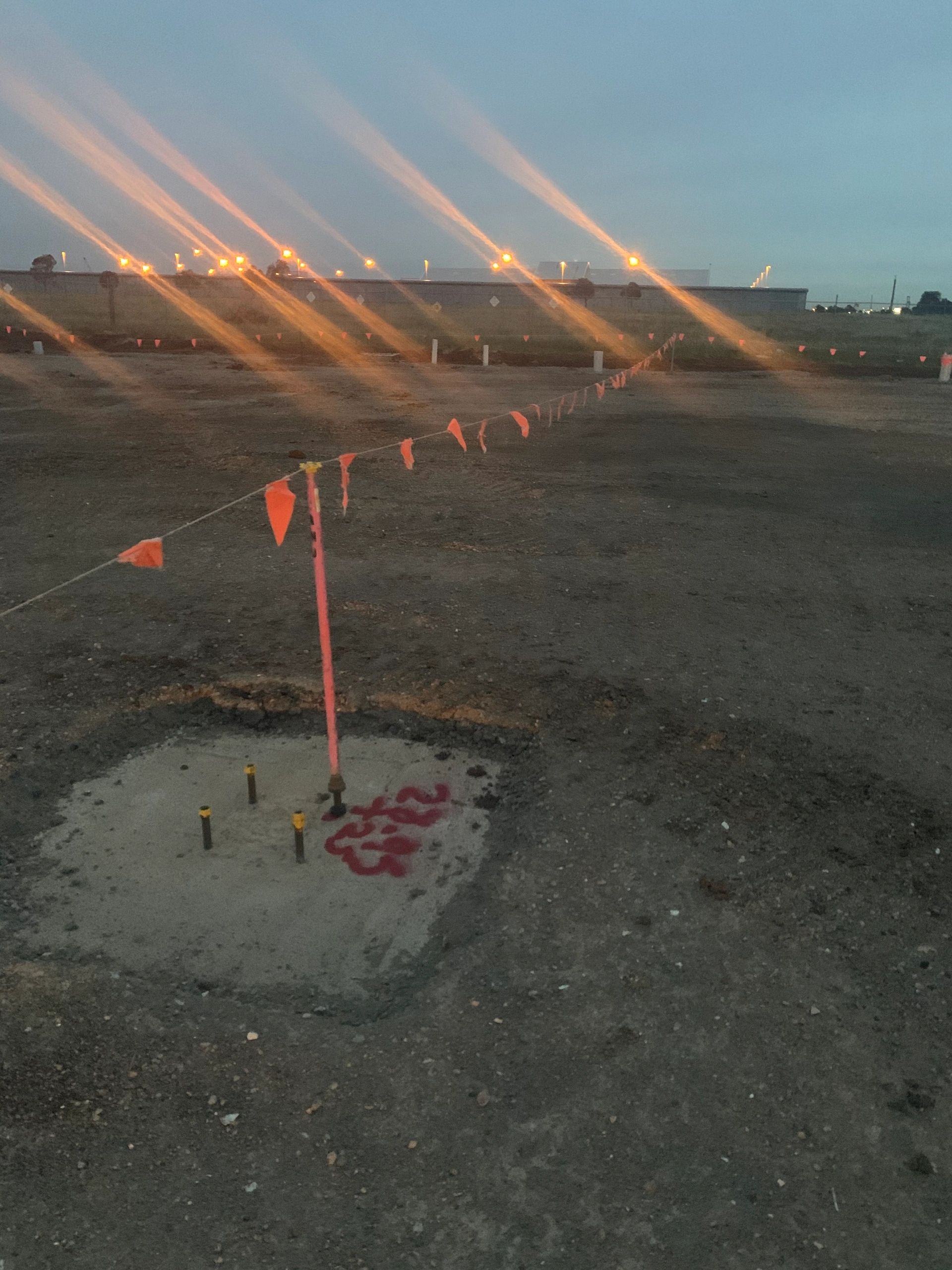 Construction site safety flagging with orange flags forming a barricade line