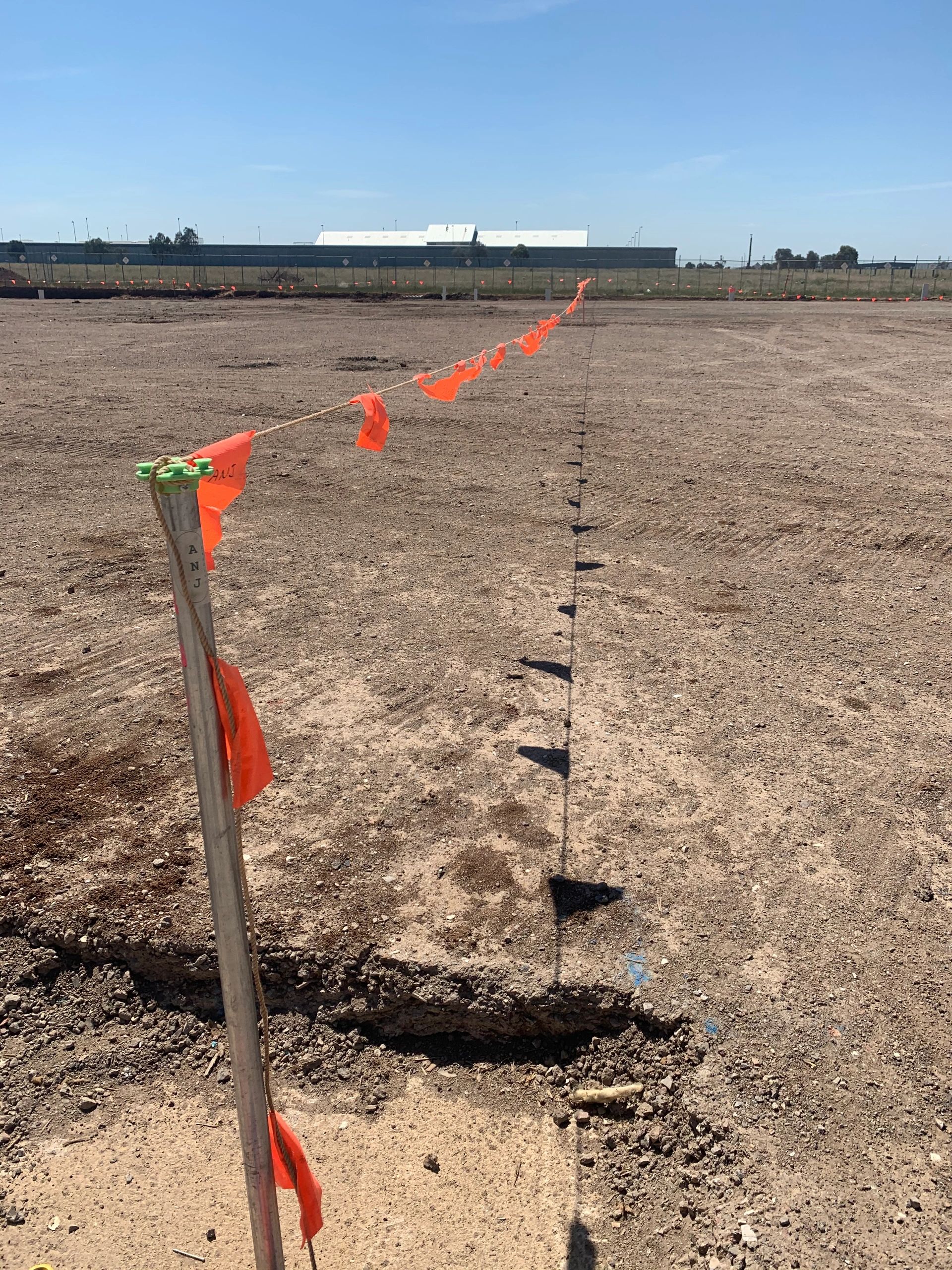 Surveying site with safety flagging tape and construction markers